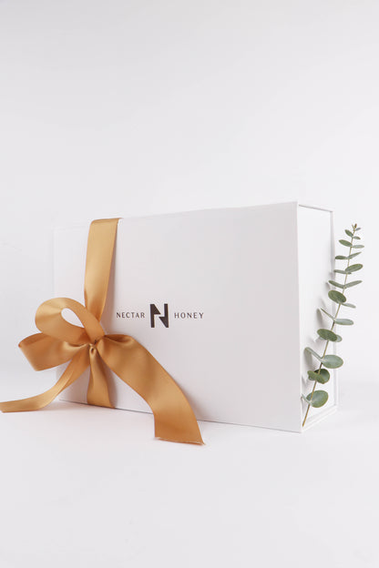 White gift box with a gold ribbon and Nectar Honey branding on a white background